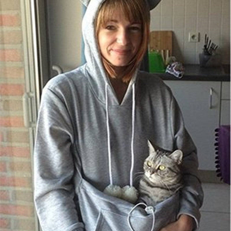 Woman wearing hoodie with pet pouch 