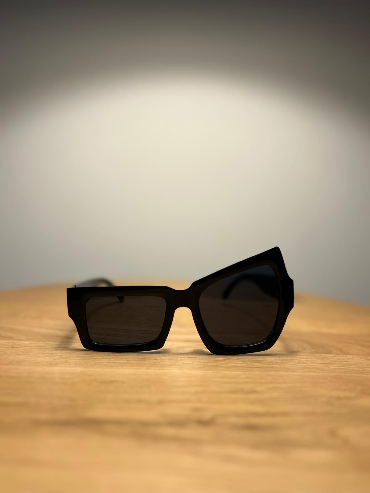 Black sunglasses on a wooden surface with a neutral background